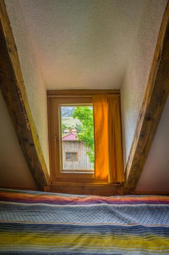 a window with an orange curtain in a room at Maple village in Žabljak