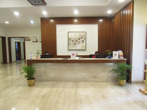 a lobby with people sitting at a reception desk at Ramanashree California Resort in Yelahanka