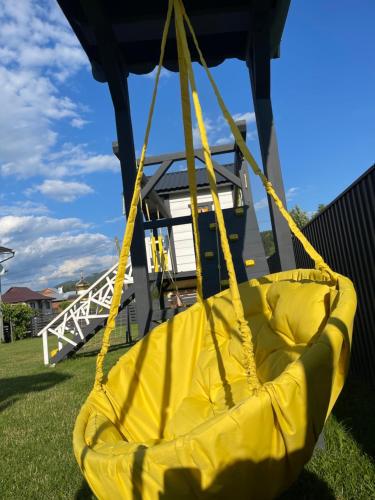a yellow swing hanging from a gazebo at Weekend house in Verkhovyna