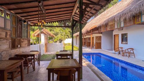ein Resort mit einem Pool sowie Tischen und Stühlen in der Unterkunft Bae Gili Inn in Gili Air