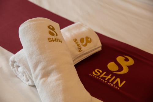 ein Paar zusammengerollte Handtücher auf einem Bett in der Unterkunft SHIN Hotel Nimman ChiangMai in Chiang Mai