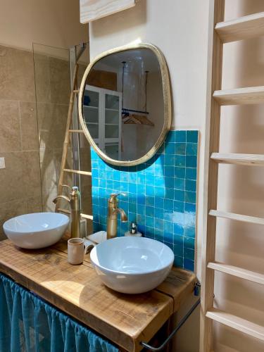 une salle de bain avec deux lavabos blancs et un miroir dans l'établissement Charmante maison climatisée avec 2x ch et 2x sdb, à Arles