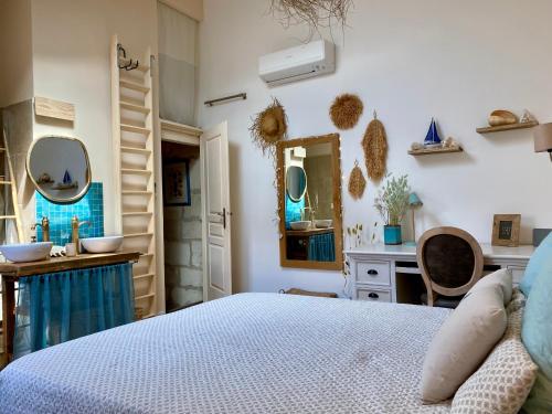 une chambre avec un lit, un lavabo et un miroir dans l'établissement Charmante maison climatisée avec 2x ch et 2x sdb, à Arles
