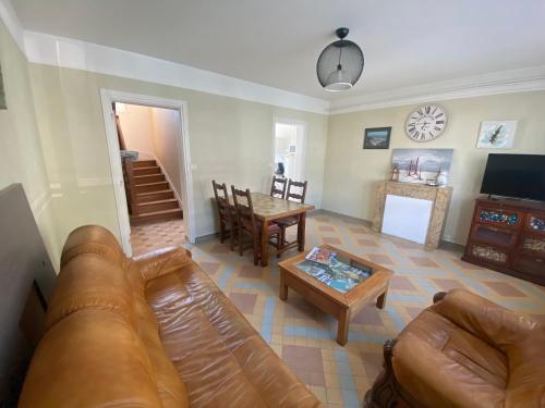 un salon avec un canapé et une table dans l'établissement gîte iaorana - maison en centre ville, à Valognes