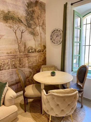 une table et des chaises dans une pièce avec un tableau dans l'établissement Charmante maison climatisée avec 2x ch et 2x sdb, à Arles