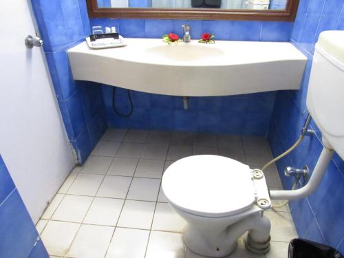 a bathroom with a toilet and a sink at Ramanashree California Resort in Yelahanka