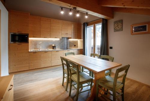 a kitchen and dining room with a wooden table and chairs at Chalet Silvi Residence in Bormio