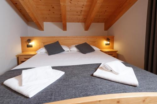 a bedroom with a bed with white towels on it at Chalet Silvi Residence in Bormio
