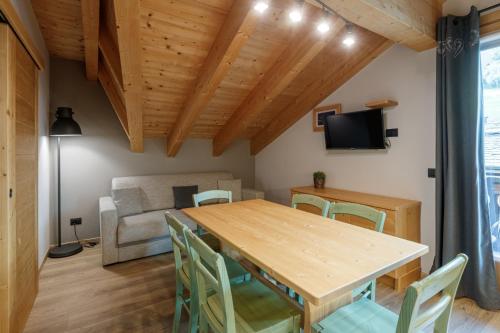 a dining room with a wooden table and chairs at Chalet Silvi Residence in Bormio