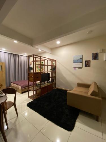 a living room with a couch and a bedroom at Homestay Timurbay in Kuantan