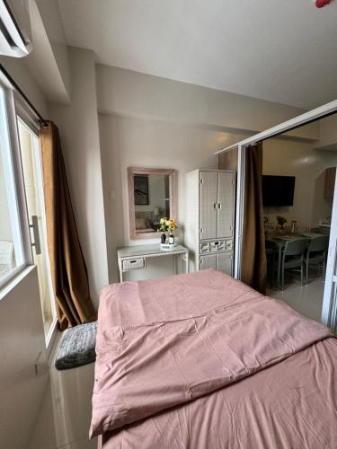 Un dormitorio con una cama con una manta rosa. en RRS Cabin, Primeworld District, en Lapu Lapu City