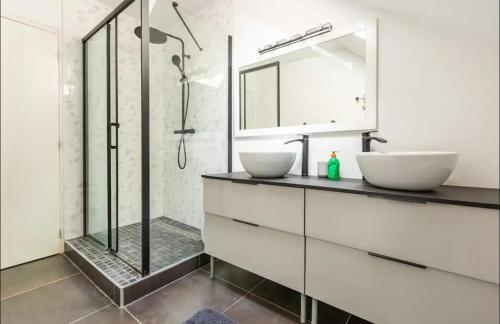 une salle de bain avec deux lavabos et une douche dans l'établissement Le Duplex du BIPLAN, à Lille