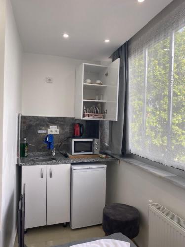 a small kitchen with a microwave and a window at Amida Family pansiyon in Istanbul