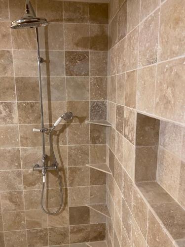 um chuveiro na casa de banho com azulejos castanhos em La Bouscatière em Moustiers-Sainte-Marie