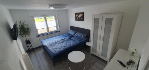 a small living room with a blue couch and a table at Kleine gemütliche Wohnung in Geislingen