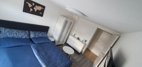 a small bedroom with a blue bed and a staircase at Kleine gemütliche Wohnung in Geislingen