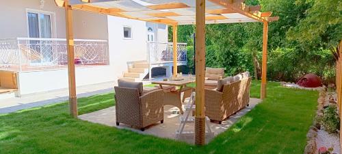 a patio with a table and chairs under a pergola at Villa Pandesia in Afitos