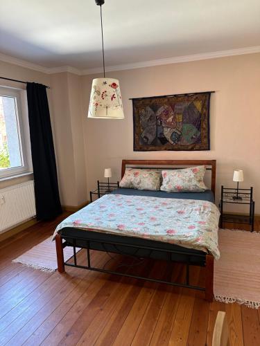 a bedroom with a bed in a room with wooden floors at Ferienwohnung Mathilda in Waren
