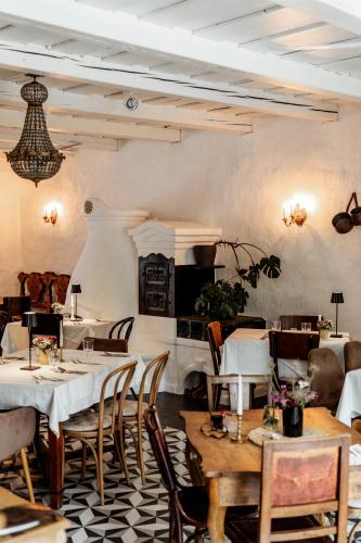 a restaurant with tables and chairs in a room at Kővirág Panzió in Köveskál