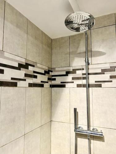 La salle de bains est pourvue d'une douche et d'une lampe. dans l'établissement Villa Les Ruches - Piscine & Clim, à Bras