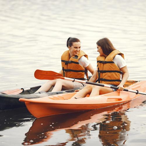 two women are sitting in a kayak on the water at Camping L'oasis Du Berry in Saint-Gaultier
