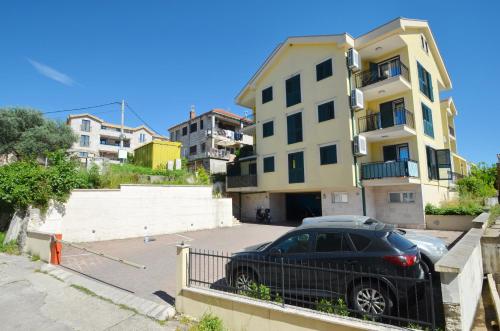 a black car parked in a parking lot in front of a building at Discovery Point Apartments in Tivat
