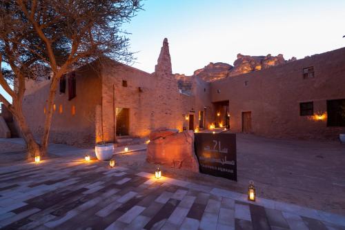 a building with lights in the middle of a courtyard at Dar Tantora The House Hotel in AlUla