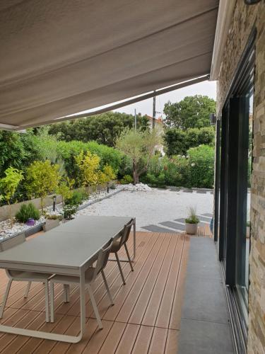 un patio avec une table et des chaises sur une terrasse dans l'établissement Villa Daniel Saint Aygulf, à Saint-Aygulf