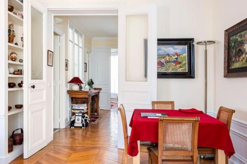 une salle à manger avec une table et des chaises rouges dans l'établissement YOUR HOME FROM HOME near EIFFEL TOWER-INVALIDES, à Paris