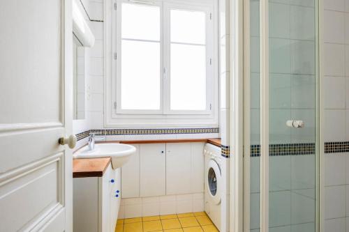 une salle de bain avec un lavabo et une machine à laver dans l'établissement YOUR HOME FROM HOME near EIFFEL TOWER-INVALIDES, à Paris