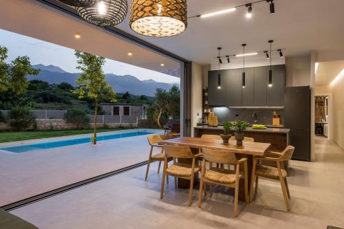 a kitchen and dining room with a table and chairs at VILLA PETRA PHILIPPOS heated pool optional in Khámbatha