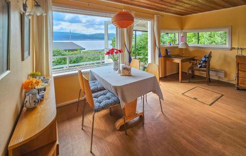 a dining room with a table with flowers on it at Nice Home In Klokkarstua With Wifi in Ustad