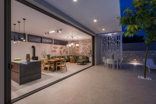 a living room with a table and a dining room at VILLA PETRA PHILIPPOS heated pool optional in Khámbatha