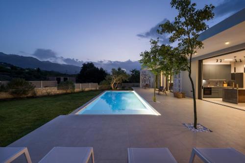 a swimming pool in the backyard of a house at VILLA PETRA PHILIPPOS heated pool optional in Khámbatha