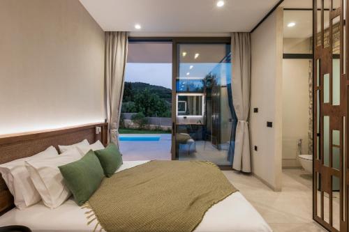 a bedroom with a bed and a view of a pool at VILLA PETRA PHILIPPOS heated pool optional in Khámbatha