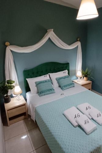 1 dormitorio con 1 cama con cabecero verde y almohadas en Eolos Villa, en Parga