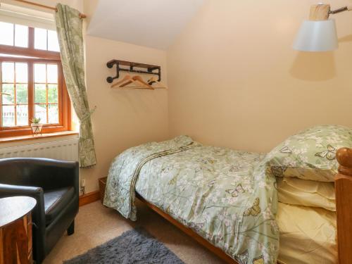 a bedroom with a bed and a chair at Ty Pili Pala in Betws-y-coed