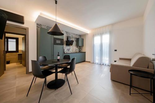 a dining room and living room with a table and chairs at ApartmentsGarda - Residenza Garda Deluxe in Garda