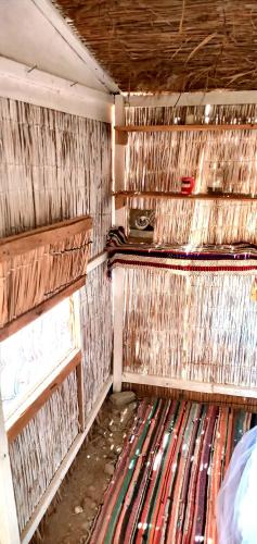 an empty room with wooden shelves and a rug at COSMOS nature Lodge and Spiritual community in Dahab