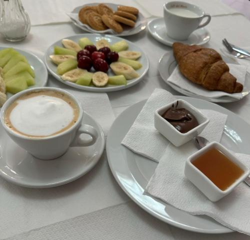 una mesa con platos de comida y una taza de café en Hotel Kaloshi, en Tirana