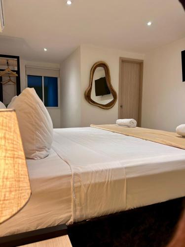 a large white bed in a room with a mirror at Hotel Sol Caribe Cartagena in Cartagena de Indias