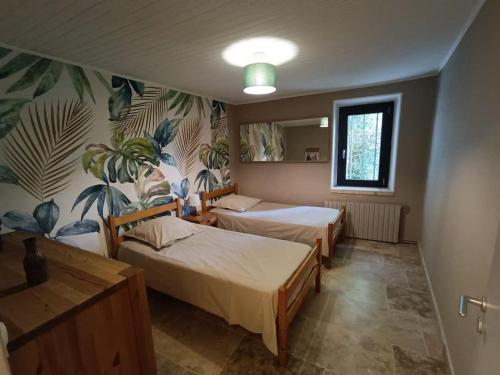 - une chambre avec 2 lits et un mur orné de plantes dans l'établissement Maison de village avec parking à 5 min de Vaison La Romaine, à Puyméras