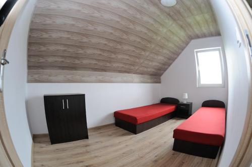 an attic room with two beds and a window at Hibiskus - domki letniskowe in Jastrzębia Góra