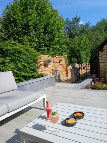 ナミュールにあるLe Loft du Renard, Gîte rural à Namur Wépionのソファとテーブルの上に食べ物のボウルが置かれたパティオ