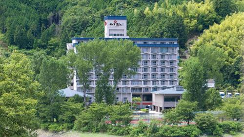 a large building in the middle of a forest at Hyper Resort Villa Shionoe in Shionoe