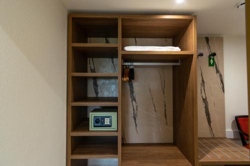a book shelf with a clock in a room at Hotel Tiziana in Losone