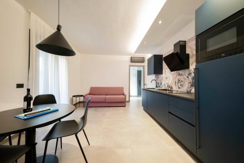 una cucina e un soggiorno con divano rosa di ApartmentsGarda - Residenza Garda Deluxe a Garda