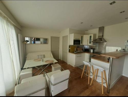une cuisine avec une table et des chaises dans une pièce dans l'établissement T2 centre, plage à 2 minutes, parking, à Arcachon