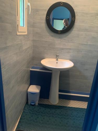 une personne prenant une photo d'une salle de bains avec lavabo dans l'établissement Chambre Azur, à Tournehem