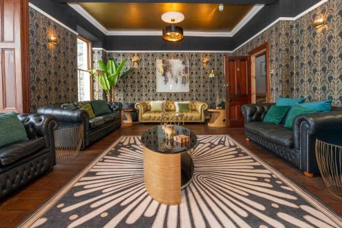 a living room with leather furniture and a table at The Belmont Barmouth in Barmouth